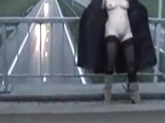 Exhibitionist wife in stockings and long coat flashing motorists on a bridge