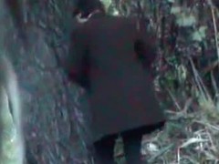 A business woman goes to take a piss in the autumn forest