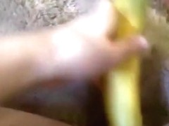 Girl masturbates her shaved pussy closeup with a banana