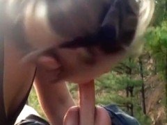 Horny babe sucking a chocolate covered dick in the woods