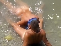Girl sucks dick her boyfriend in the surf at a public beach