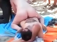 Interracial threesome on a nude beach with lots of spectators