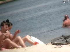 Flat chested brunette and mature blonde on beach voyeur vid