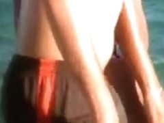 a brunette on the beach with a giant and divine ass