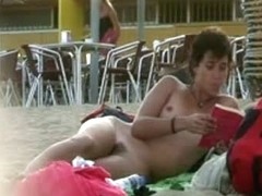 Short haired sweetie filmed on a nudist beach