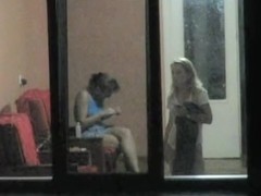 Brunette and blonde girls voyeured through hostel window