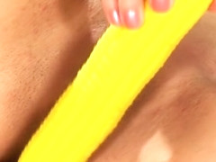 Provoking blonde slides a yellow dildo in and out of her aching pussy