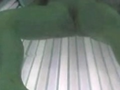 Girl masturbates while in a sunbed