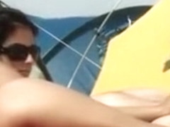 Il masse les belles fesses de sa femme sur la plage